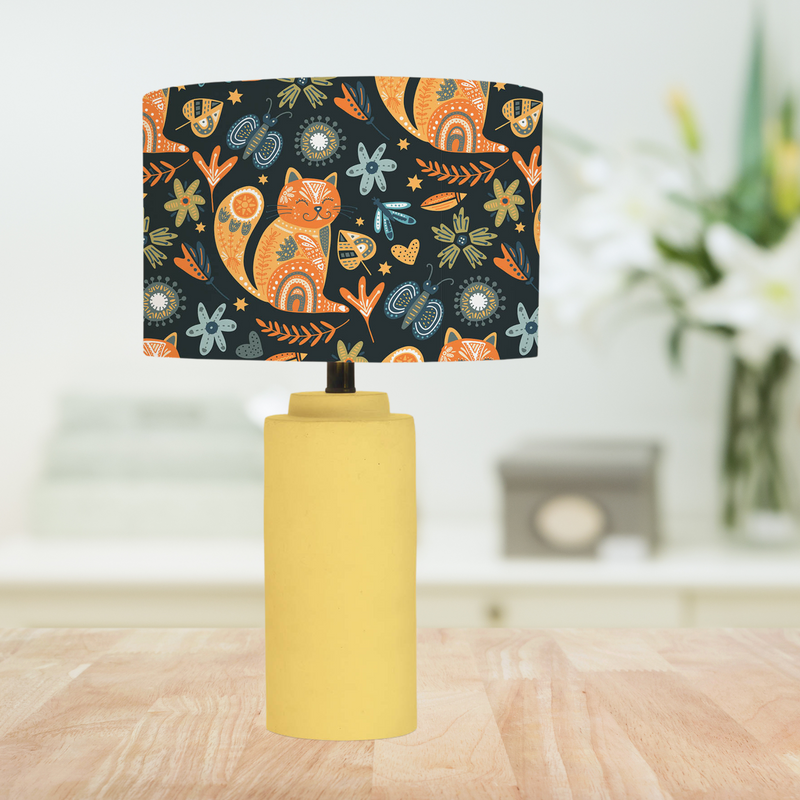 This handmade lampshade features a boho inspired pattern of content little pussy cats among leaves, florals and butterflies in tones of orange, blue and green on a black background.   