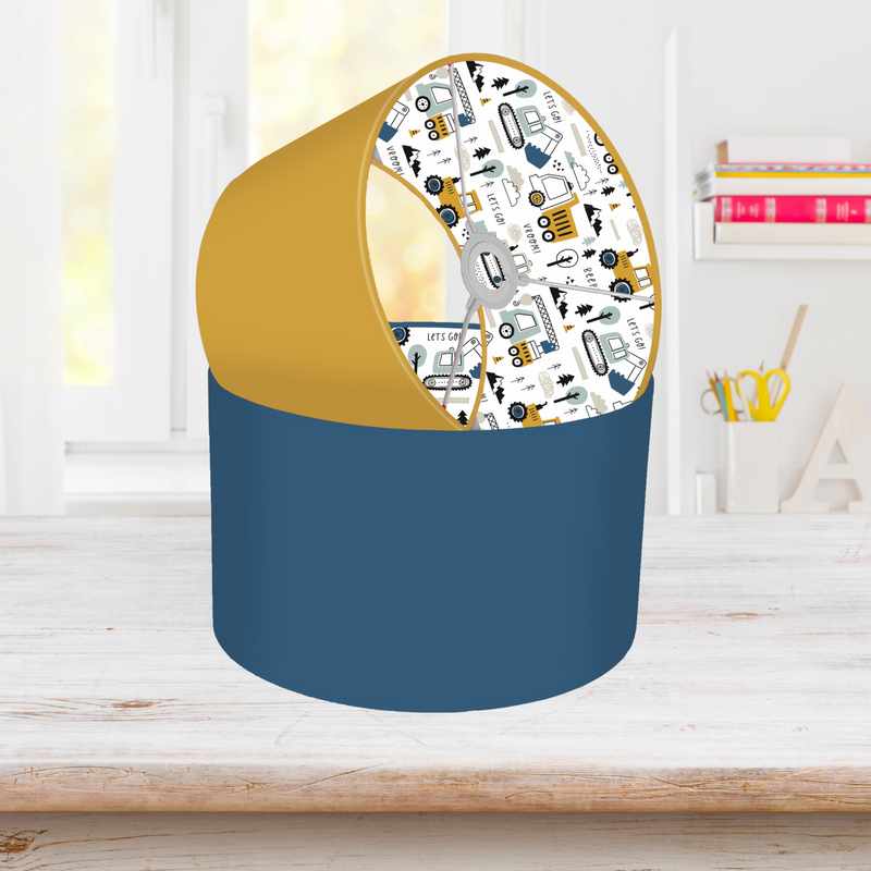 This fun lined ceiling lampshade features our best selling 'Let's Go' pattern featuring construction vehicles including cranes, tractors and diggers on the inside, and your choice of a solid blue, mustard or grey on the outside.  