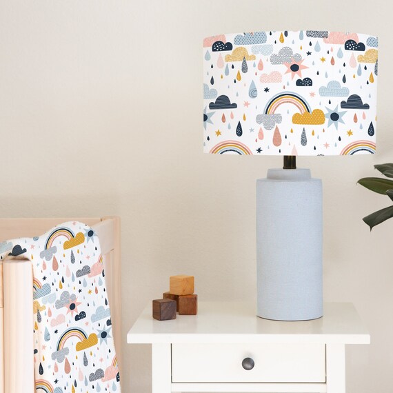 Children's bedroom and nursery lampshade lightshade for ceiling fitting or lamp base featuring rainbows, clouds and raindrops in gold, pinks, black and blue.