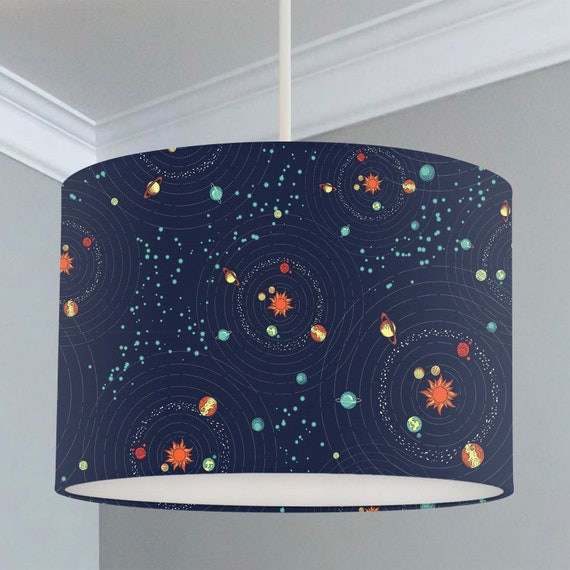 Children's bedroom and nursery ceiling lampshade featuring a space scene of assorted planets in a solar system in oranges, reds, yellows and greens on a dark blue background.